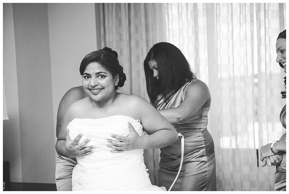 bride getting into dress smiling