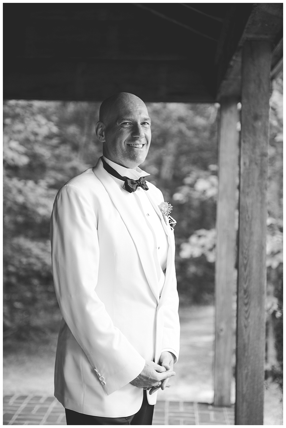 groom in tux with black bow tie