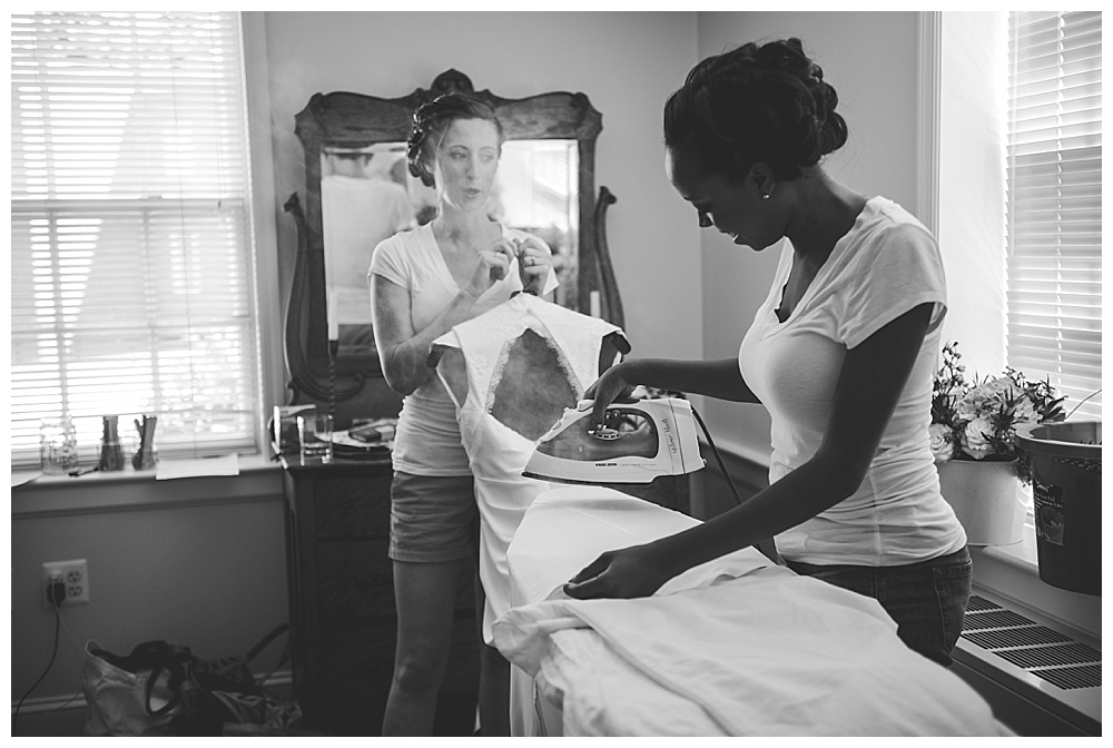 bridesmaids steaming bride's wedding gown