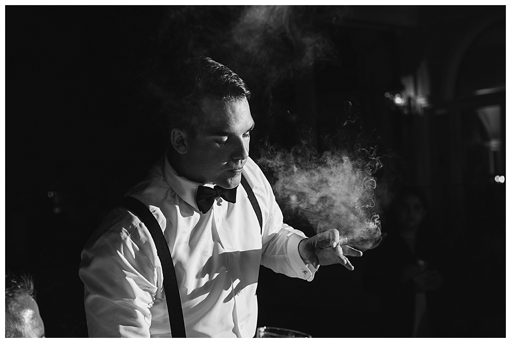 groom smoking cigars wedding
