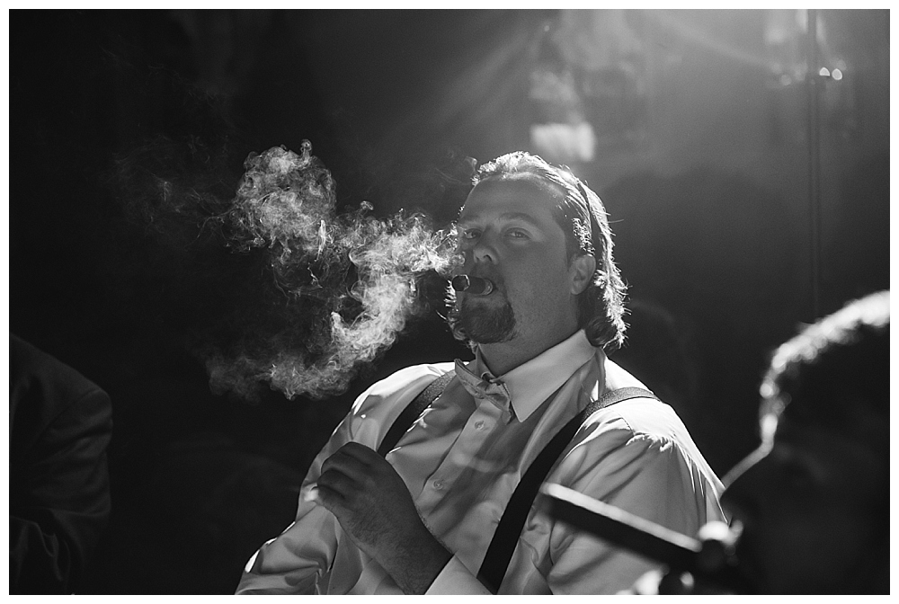 groom smoking cigars wedding