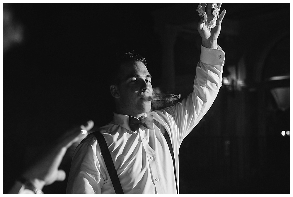 groom smoking cigars wedding