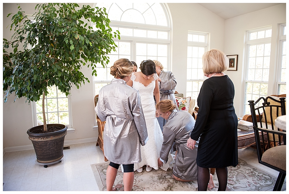 Bride putting on dress