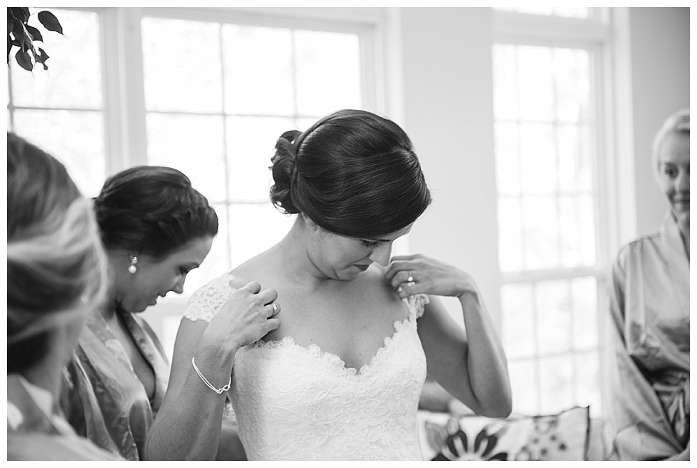 Bride putting on dress