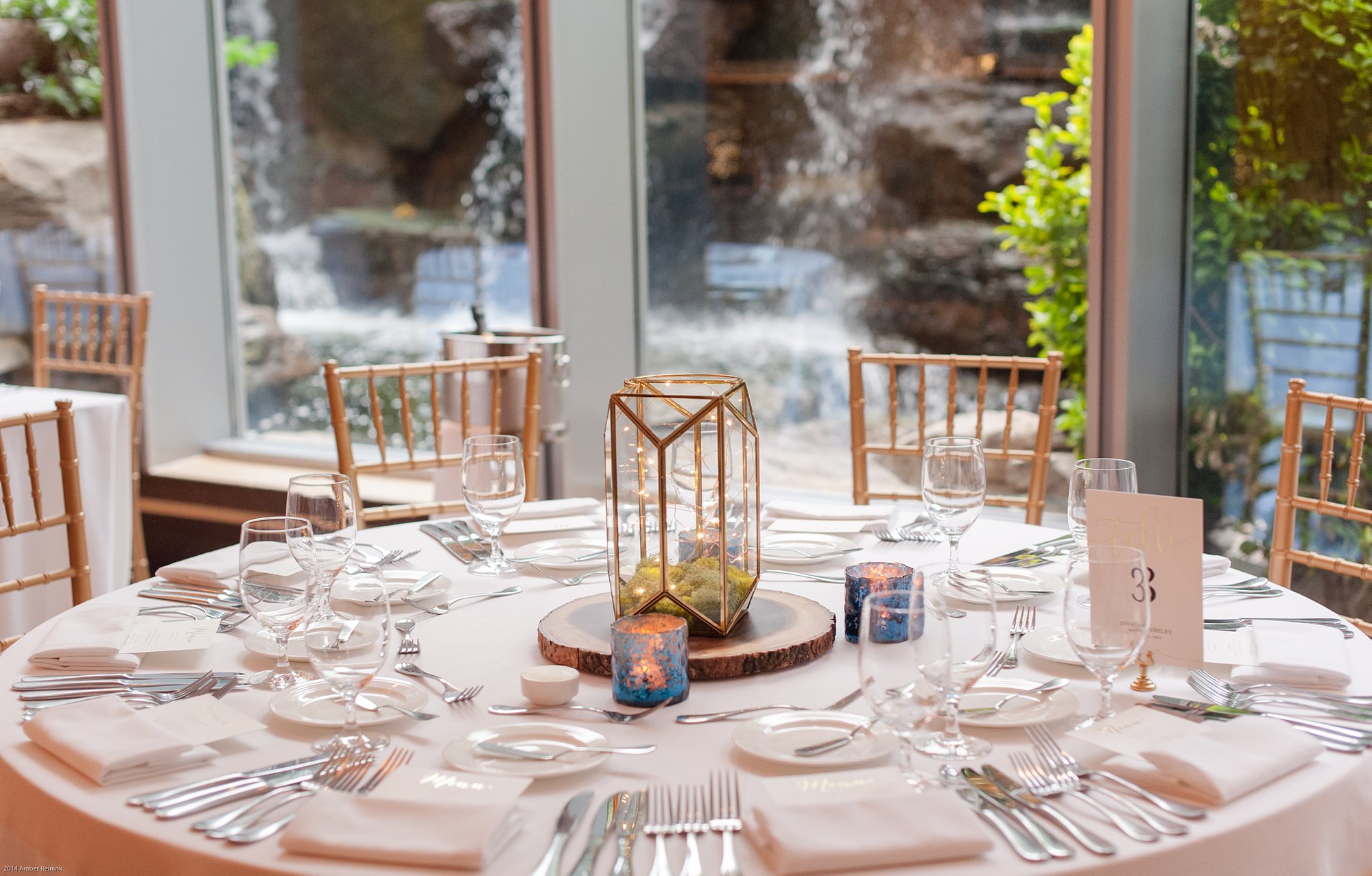 Table settings with gold lanterns and waterfall in background at 2941 restaurant wedding Vienna Virginia